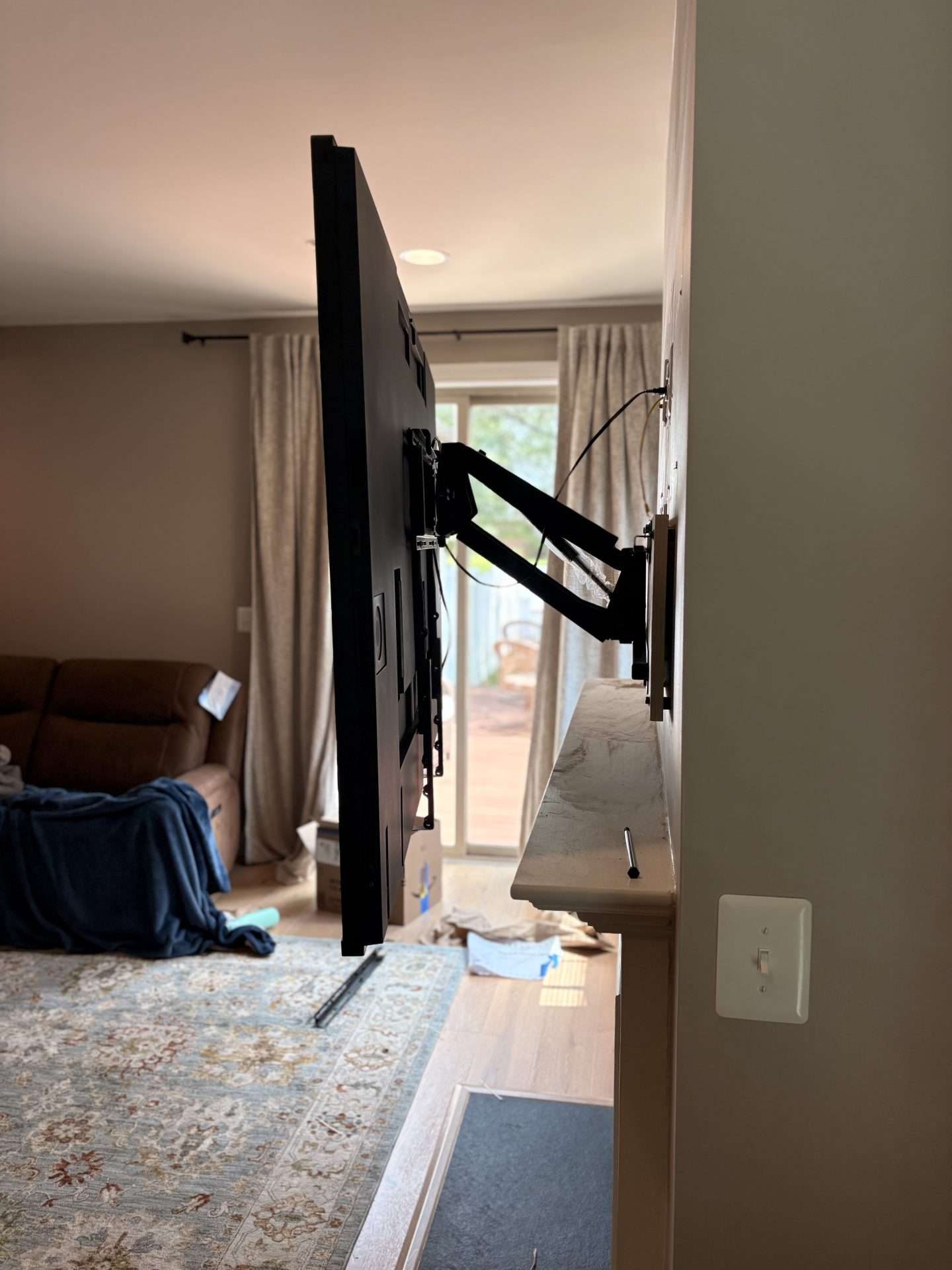 Side view of 65 inch television on pull down articulating fireplace mount