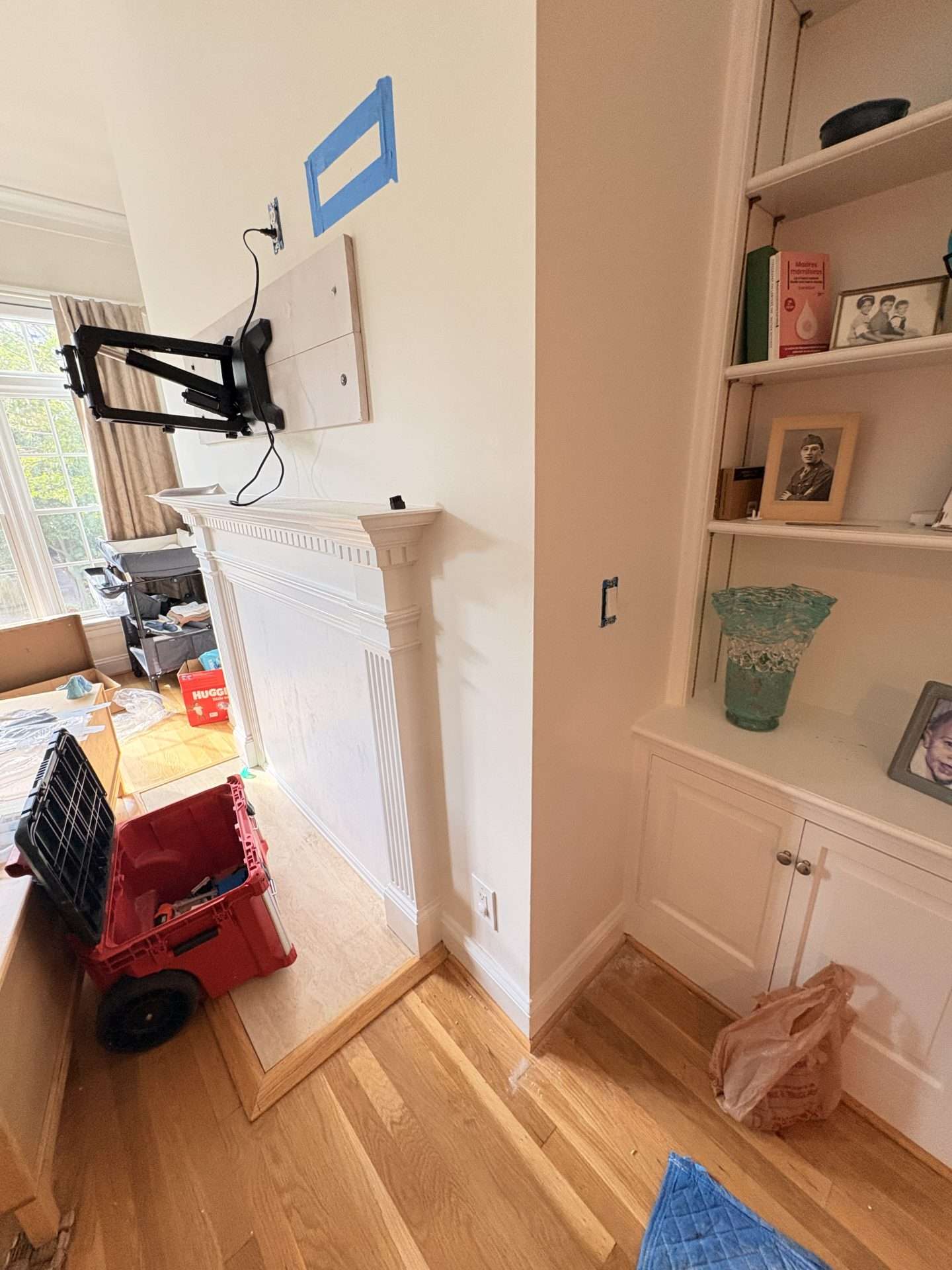 Full motion television mounting bracket installed over fireplace
